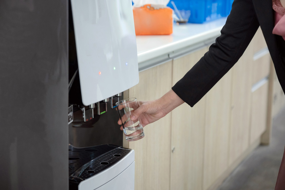 woman-hand-holding-glass-filling-cool-water-from-water-dispenser